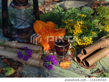 Mystic still life with old paper scrolls, healing herbs, cup and witchy ritual objects on old table. Occult, esoteric, wicca and divination concept. Mystic still life with old paper scrolls, healing herbs, cup and witchy ritual objects on old table. Occult, esoteric, wicca and divination concept. 118198564