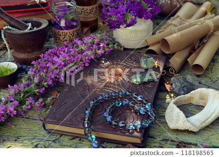 Mystic still life with magic book of spells, old paper scrolls and witchy ritual objects on old table. Occult, esoteric, wicca and divination concept. No foreign language, all symbols are fictional 118198565