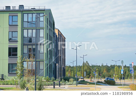 Modern apartment buildings and townhouses in residential complex. Road and lighting. Comfortable housing of new type.  118198956