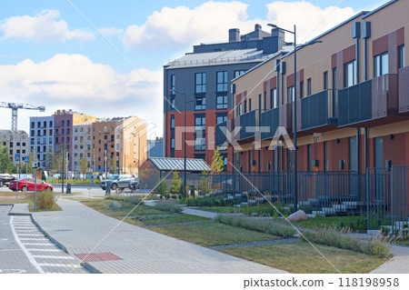 Construction of modern apartment blocks and townhouses in residential complex. Buildings and machinery on construction platform. Comfortable housing of new type. Construction of modern apartment blocks and townhouses in residential complex. Buildings and machinery on construction platform. Comfortable housing of new type. 118198958