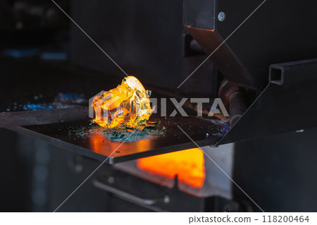 Molten glass fusing with colorful fragments on a blowing pipe Molten glass fusing with colorful fragments on a blowing pipe 118200464