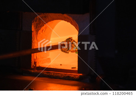 Open furnace with molten glass on a blowpipe inside, glass blowing Open furnace with molten glass on a blowpipe inside, glass blowing 118200465