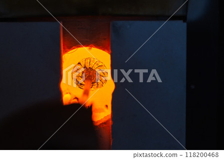 Open furnace with molten glass on a blowpipe inside, glass blowing Open furnace with molten glass on a blowpipe inside, glass blowing 118200468