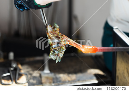 Sculpting a flower made of molten glass. Glass blowing workshop Sculpting a flower made of molten glass. Glass blowing workshop 118200470