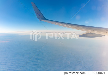 View from the airplane window at a beautiful cloudy sky and the airplane wing View from the airplane window at a beautiful cloudy sky and the airplane wing 118200821
