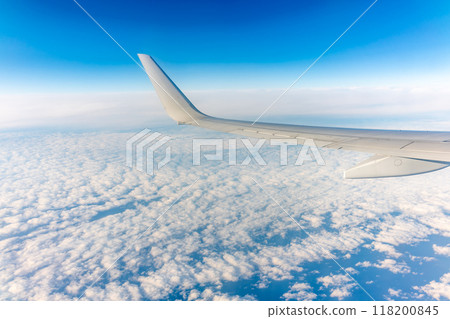 View from the airplane window at a beautiful cloudy sky and the airplane wing View from the airplane window at a beautiful cloudy sky and the airplane wing 118200845