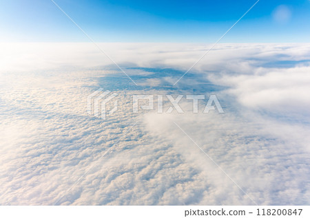 View from the airplane window at a beautiful cloudy sky and the airplane wing View from the airplane window at a beautiful cloudy sky and the airplane wing 118200847