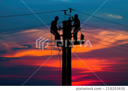 Dedicated effort - men working on electricity pole, skilled workers repairing breakdown in electricity supply, restoring essential power to community, labour day with hard work and commitment. Dedicated effort - men working on electricity pole, skilled workers repairing breakdown in electricity supply, restoring essential power to community, labour day with hard work and commitment. 118201630