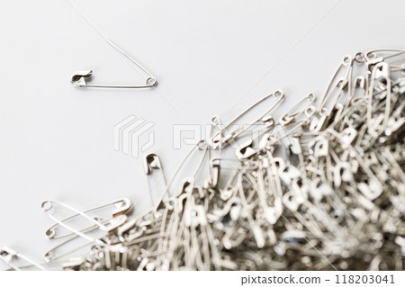 A number of stainless safety pins on white background. 118203041