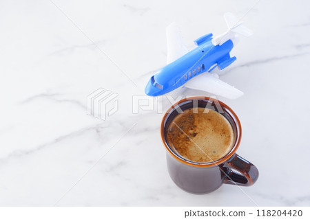 Image of a passenger plane waiting to take off and freshly brewed coffee, planning a trip Image of a passenger plane waiting to take off and freshly brewed coffee, planning a trip 118204420