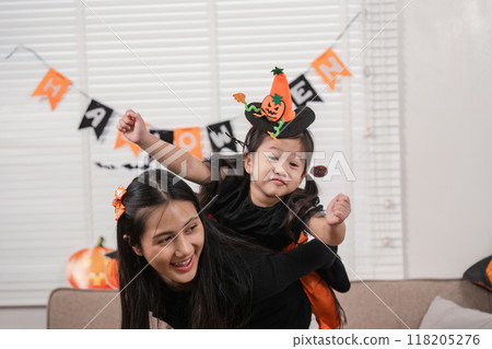 Joyful mother and daughter in Halloween costumes at home 118205276