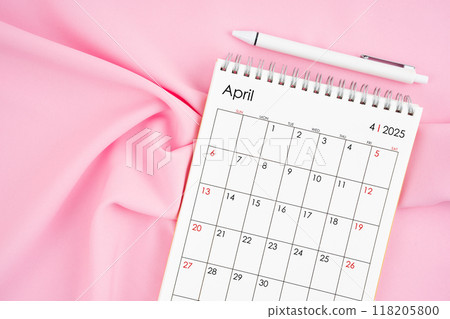 April 2025 month calendar and pen on pink fabric background. 118205800