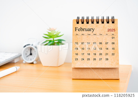 February 2025 desk calendar on worktable. February 2025 desk calendar on worktable. 118205925