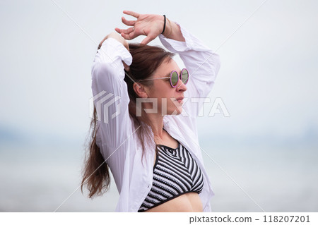 A beautiful middle-aged woman is relaxing at a resort, walking and enjoying her vacation. A beautiful middle-aged woman is relaxing at a resort, walking and enjoying her vacation. 118207201