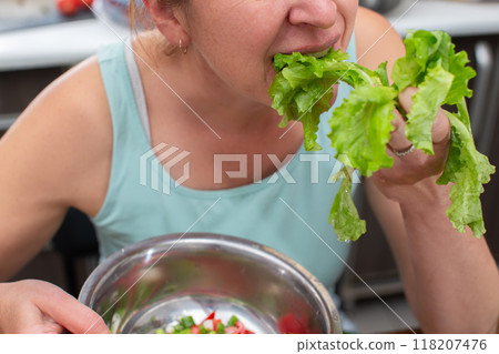 A woman's hands hold a green salad. Eat food. A woman's hands hold a green salad. Eat food. 118207476