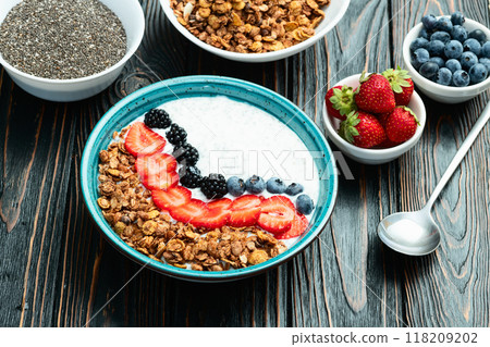 Healthy breakfast . Yogurt with berries ( strawberry , raspberry , blueberry , blackberry ) , granola and chia seeds . Top view 118209202