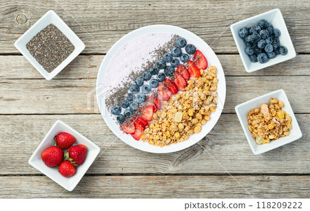 Healthy breakfast . Yogurt with berries ( strawberry , raspberry , blueberry , blackberry ) , granola and chia seeds . Top view Healthy breakfast . Yogurt with berries ( strawberry , raspberry , blueberry , blackberry ) , granola and chia seeds . Top view 118209222