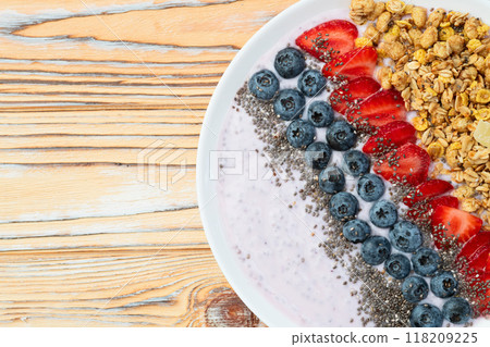 Healthy breakfast . Yogurt with berries ( strawberry , raspberry , blueberry , blackberry ) , granola and chia seeds . Top view Healthy breakfast . Yogurt with berries ( strawberry , raspberry , blueberry , blackberry ) , granola and chia seeds . Top view 118209225