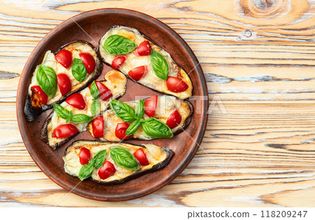 Italian mini pizza . Aubergine (eggplant ) with mozzarella cheese and basil . On rustic background 118209247