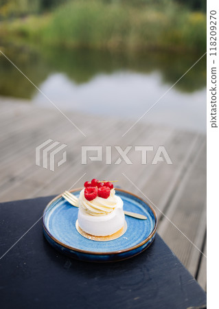 Beautiful tasty white cake with white cream and fresh raspberries at cafe. Sweet summer dieting dessert. High quality FullHD footage 118209270