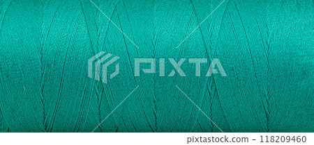Texture of threads in a spool of green color on a white background Texture of threads in a spool of green color on a white background 118209460
