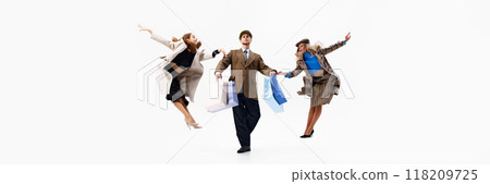 Banner. Leaping mid-air, group creates moment of shopping joy, with bags in hands against white studio background. 118209725
