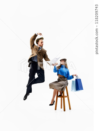 Fashionable duo, man reads newspaper, while woman holds shopping bags, merging vintage vibes with modern shopping excitement. 118209743