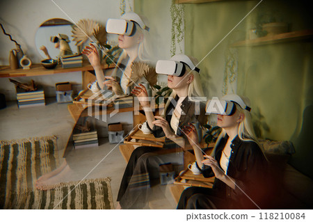 Multiple exposure shot of girl with albinism experiencing virtual reality via headset device while spending time at home 118210084