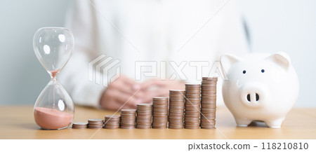Money Saving for Future Plan, Retirement fund, Pension, Investment, Wealth Business and Financial concepts. coins stack, piggy bank with sandglass on table 118210810
