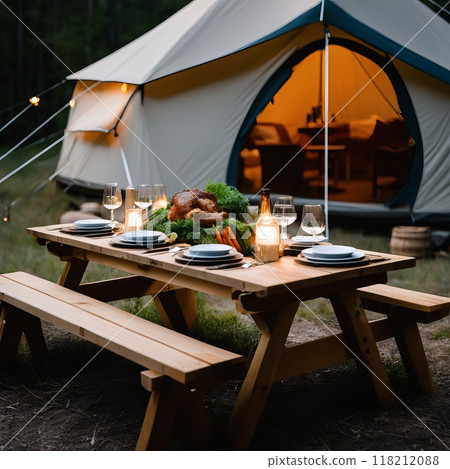 Camp dining setup with lanterns, tent lit up warmly 118212088