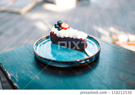 Piece of delicious homemade chocolate cake with fresh berry on a beautiful plate at city cafe, desert with chocolate 118212530