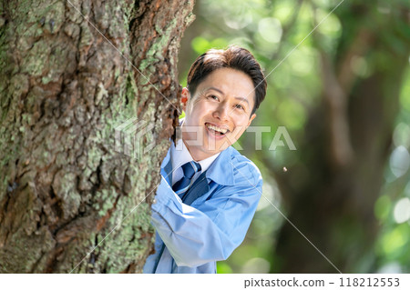 一名身穿工作服的男子躲在樹上 118212553