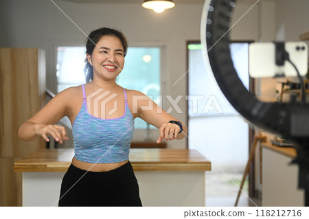 Beautiful female sport blogger streaming or recording online training class at home 118212716