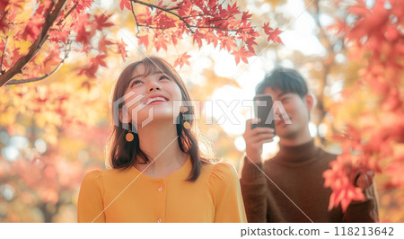 Couple taking photos of autumn leaves Couple taking photos of autumn leaves 118213642