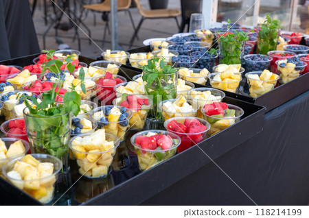 Assortment of fresh fruit cups on a tray at an outdoor market. Assortment of fresh fruit cups on a tray at an outdoor market. 118214199