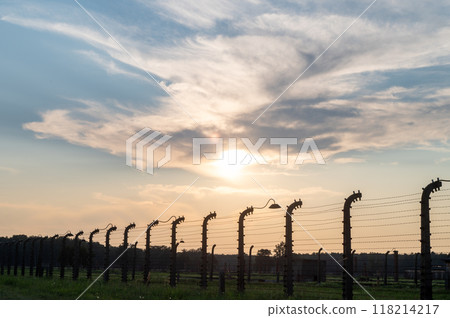 Sunset view of barbed wire fence with dramatic clouds in the sky. 118214217