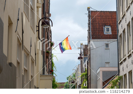 Pride flag hanging on building in a narrow European street Pride flag hanging on building in a narrow European street 118214279