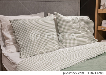 Bed with green and white checkered pillows and matching bedding. 118214288