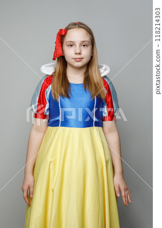 Cheerful child girl with brown hair wearing snow white dress looking at camera on white background 118214303