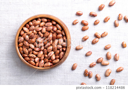 Cranberry beans, Borlotti beans in wooden bowl on linen. Tan colored streaked with red variety of the common bean Phaseolus vulgaris, also known as Borlotto, Roman, saluggia, gadhra or rosecoco bean. 118214486