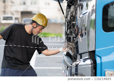 一名男子檢查一輛大卡車的引擎油 118214605