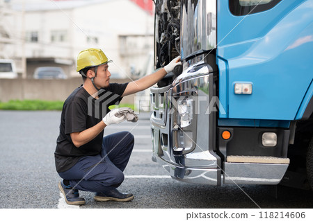 一名男子正在檢查一輛大卡車 118214606
