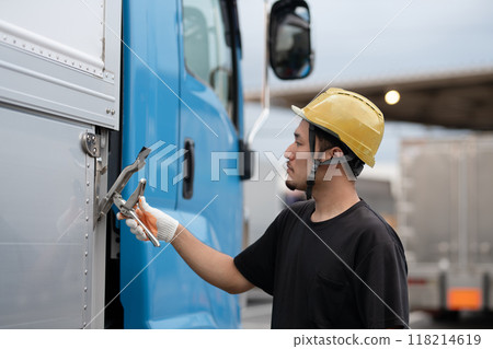 A man hooking up a large truck 118214619