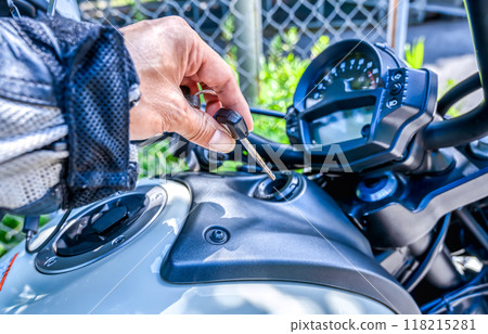 Man starting a motorcycle engine 118215281