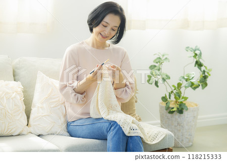 一位中年婦女在客廳織毛衣 一位中年婦女在客廳織毛衣 118215333