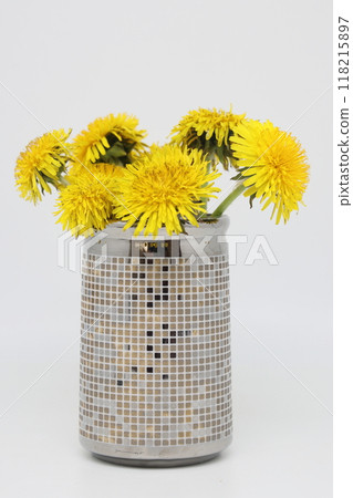 In a vase a Bright yellow bouquet of field dandelions, plucked from a spring meadow 118215897