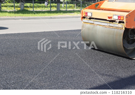 Asphalt road roller press new hot asphalt on the roadway on a road construction site. Heavy Asphalt road roller press new hot asphalt on the roadway on a road construction site. Heavy 118216310