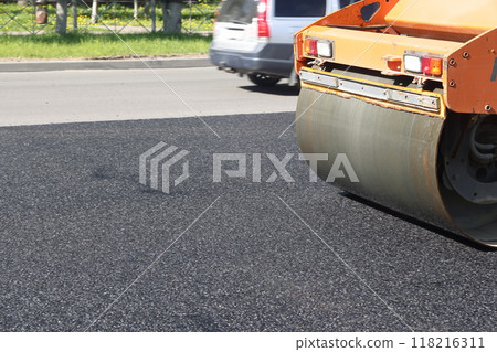 Asphalt road roller press new hot asphalt on the roadway on a road construction site. Heavy Asphalt road roller press new hot asphalt on the roadway on a road construction site. Heavy 118216311