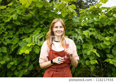 Professional woman sommelier testing wine in wine glass with tasting and smelling outdoors during sunset in a vineyard. High quality FullHD footage Professional woman sommelier testing wine in wine glass with tasting and smelling outdoors during sunset in a vineyard. High quality FullHD footage 118217438