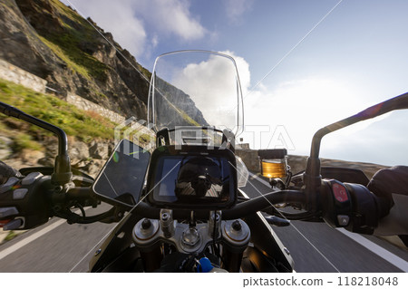 Motorbiker riding in Italian Alps during sunrise, dramatic sky. Travel and freedom, outdoor activities Motorbiker riding in Italian Alps during sunrise, dramatic sky. Travel and freedom, outdoor activities 118218048